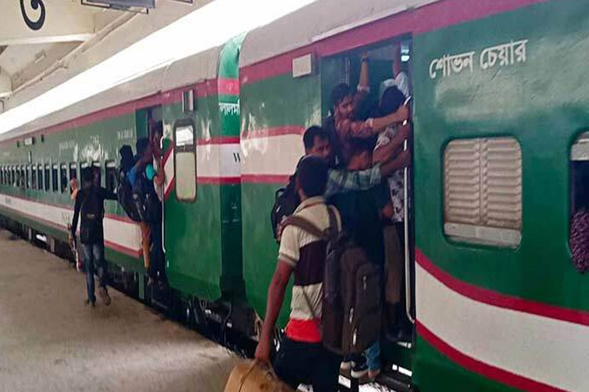 জায়গা না পেয়ে ট্রেনের দরজায় ঝুলে রাজধানী ছাড়ছে মানুষ